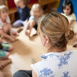 Eine Frau sitzt vor mehreren Kindern