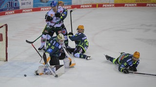 Eishockey-Spieler der Fischtown Pinguins verteidigen mit vollem Körpereinsatz das Tor.