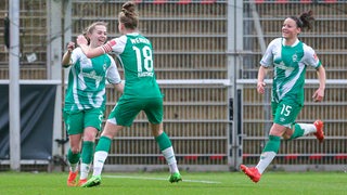 Die Werder-Fußballerinnen Lina Hausicke und Jasmin Sehan jubeln auf dem Spielfeld mit Torschützin Nina Lührßen.