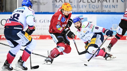 Der Eishockey-Spieler Ziga Jeglic von den Fischtown Pinguins kämpft gegen zwei Berliner Spieler um den Puck.
