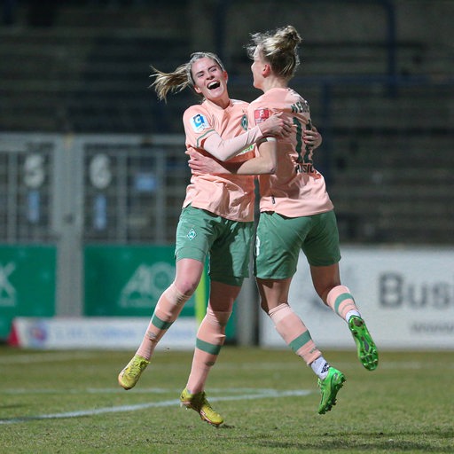 Die Werder-Spielerinnen Reena Wichmann und Lina Hausicke springen sich auf dem Spielfeld jubelnd in die Arme.