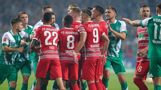 Mehrere Spieler von Augsburg und Werder liefern sich ein hitziges Wortgefecht.