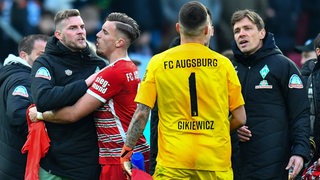 Augsburg-Torwart Rafal Gikiewicz gerät mit Werder-Stürmer Marvin Ducksch und dem Sportlichen Leiter Clemens Fritz verbal aneinander.