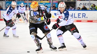 Pinguins-Spieler Jake Virtanen und Nürnberg-Akteur Marcus Weber kämpfen um den Puck.