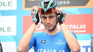 Radprofi Lennard Kämna richtet sich den Helm vor dem Etappenstart bei Tirreno-Adriatico.