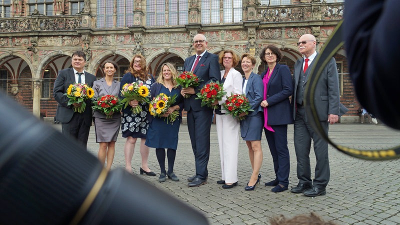 Die neun Bremer Senatsmitglieder posieren nach ihrer Vereidigung auf dem Marktplatz vor dem Rathaus.