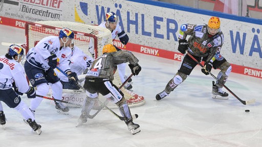 Eishockey-Spieler der Fischtown Pinguins versuchen gegen den Widerstand der Münchner Spieler den Puck ins Tor zu schießen.