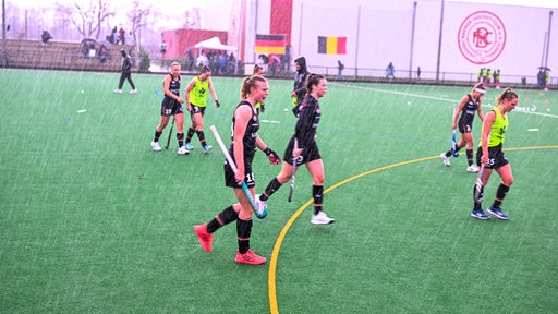 Heftiger Platzregen während sich die deutschen Hockey-Nationalspielerinnen auf dem Platz des Bremer HC vor dem Anstoß einspielten.