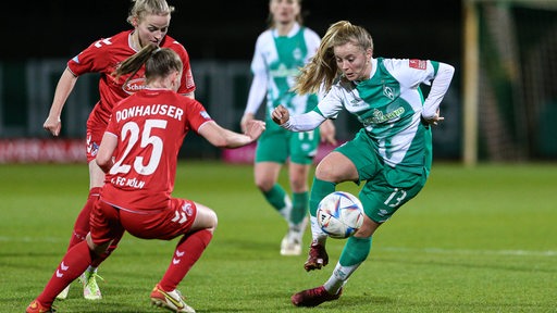 Werder-Spielerin Ricarda Walkling dribbelt zwei Gegenspielerinnen aus.