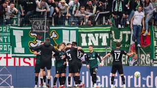 Die Werder-Spieler bejubeln das 2:2-Unentschieden in Mainz vor der Auswärtskurve.