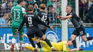 Roland Sallai trifft zum 1:1 für Freiburg. Jiri Pavlenka liegt am Boden.