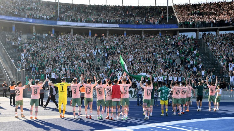 Die Werder-Spieler feiern nach dem Sieg im Berliner Olympiastadion vor der Tribüne mit Tausenden Bremer Fans.