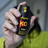 Ein Mann hält eine Dose Pfefferspray in die Kamera.