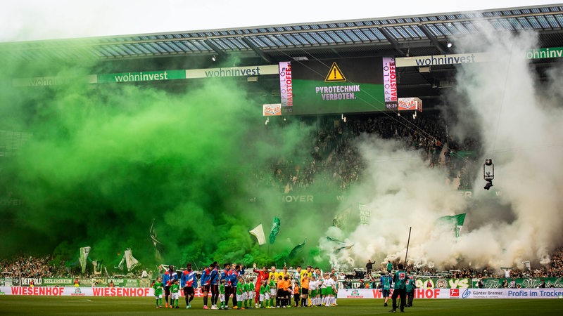 Im Weser-Stadion steigen vor dem Spiel zwischen Werder und Bayern dichte grüne und weiße Nebelschwaden im Fanblock auf.