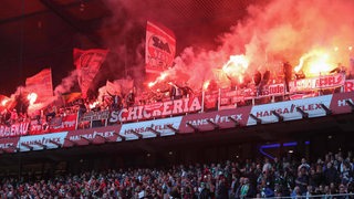 Bayern-Fans entzünden jede Menge rot brennende Pyrotechnik im Gästeblock des Weser-Stadions.