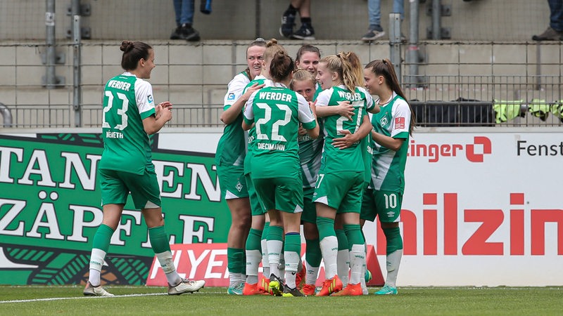 Fußball-Spielerinnen des SV Werder Bremen kommen jubelnd zusammen nach einem Treffer gegen Freiburg.