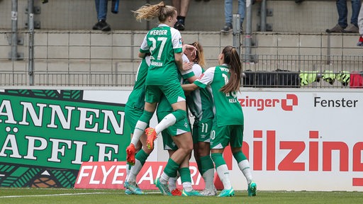 Werders Fußballerinnen kommen jubelnd zusammen nach einem Tor gegen Freiburg.