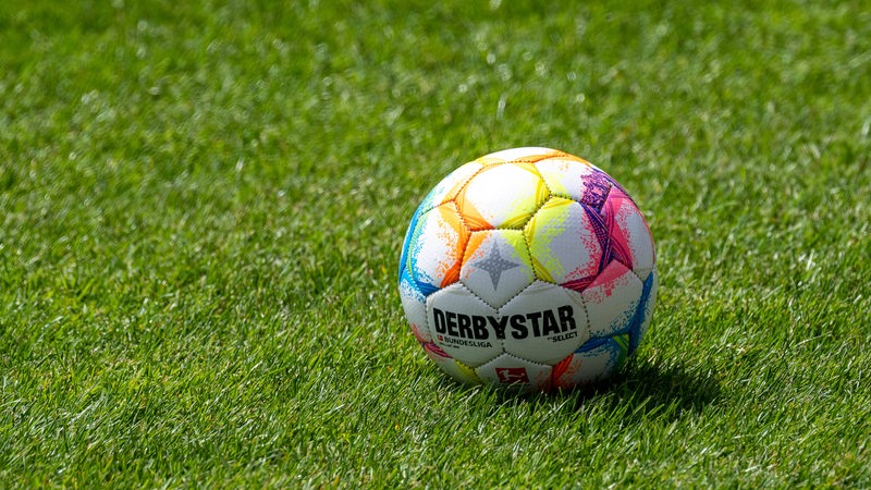 Ein Derbystar-Fußball liegt auf einem Rasenplatz.