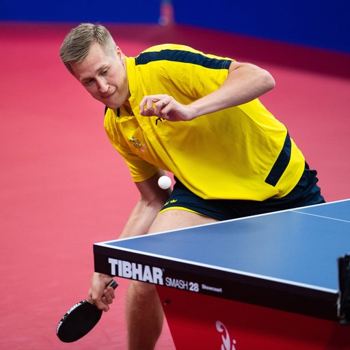 Tischtennisspieler Mattias Falck tief in den Knien bei einem Vorhandschlag.