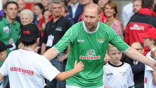 Dieter Eilts läuft abklatschend an Kindern vorbei ins Stadion