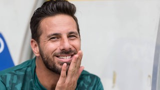 Claudio Pizarro lacht und stützt den Kopf leicht auf der flachen Hand an.