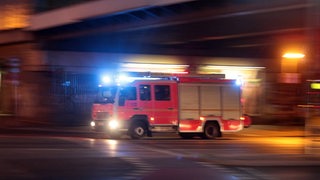 Ein Feuerwehrauto in der Nacht mit Blaulicht