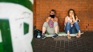 Werder-Fans sitzen frustriert vor dem Weser-Stadion.