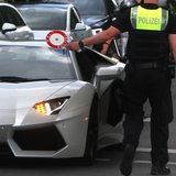 Polizist hält einen Sportwagen an (Symbolbild)