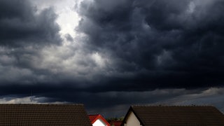 Gewitterwolken hängen über Hausdächern