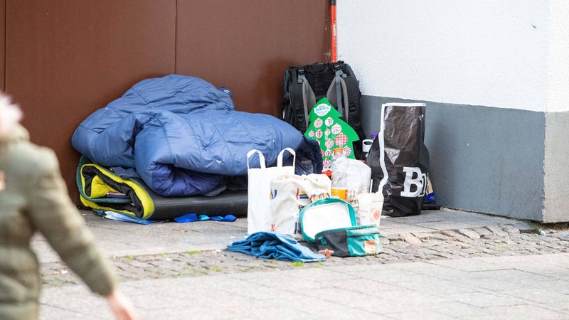 Hab und Gut eines Obdachlosen in einer Nische in einer Einkaufsstraße.