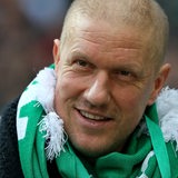 Ivan Klasnic lächelt mit wenigen Haaren auf dem Kopf und Werder-Schal um den Hals.