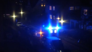 In der Dunkelheit leuchten blaue Lichter eines Feuerwehrsfahrzeugs.