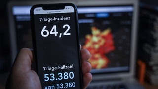 Screen eines Samrtphones mit einer 7-Tage-Inzidenz von 64,2