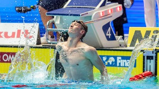 Schwimmer Florian Wellbrock spritzt vor Freude das Wasser hoch nach seinem Gold-Gewinn über 1.500 Meter Freistil bei der WM.