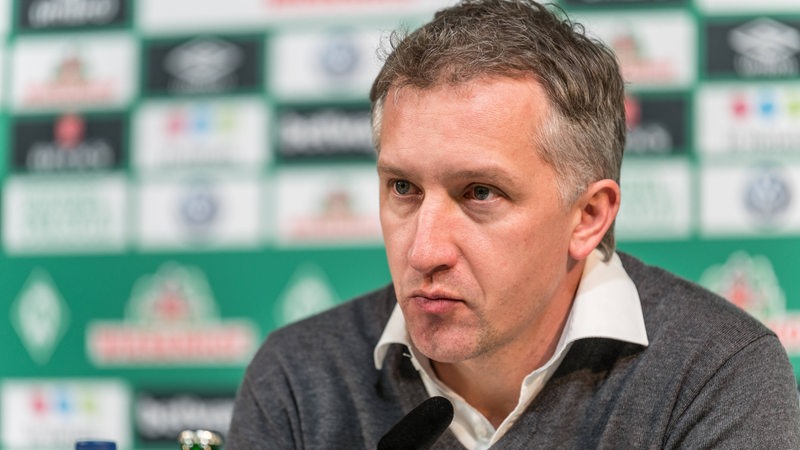 Sportchef Baumann auf dem Podium einer Werder-Pressekonferenz.