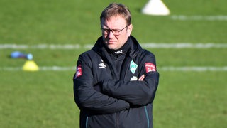 Werders Co-Trainer Thomas Horsch steht mit verschränkten Armen nachdenklich beim Werder-Training.