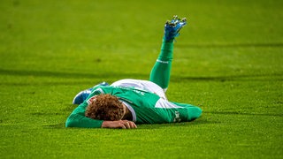Werder-Stürmer Joshua Sargent liegt verletzt am Boden.