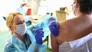 Eine Ärztin impft einen Patienten mit AstraZeneca gegen das Coronavirus.