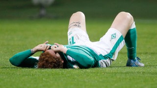 Werder-Stürmer Joshua Sargent liegt enttäuscht auf dem Rasen.