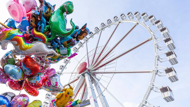 Eine Luftballontraube ist vor einem Riesenrad auf dem Freimarkt 2019 in Bremen zu sehen.