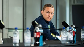 Ludwig Augustinsson sitzt vor dem EM-Start bei einer Pressekonferenz der schwedischen Nationalmannschaft.