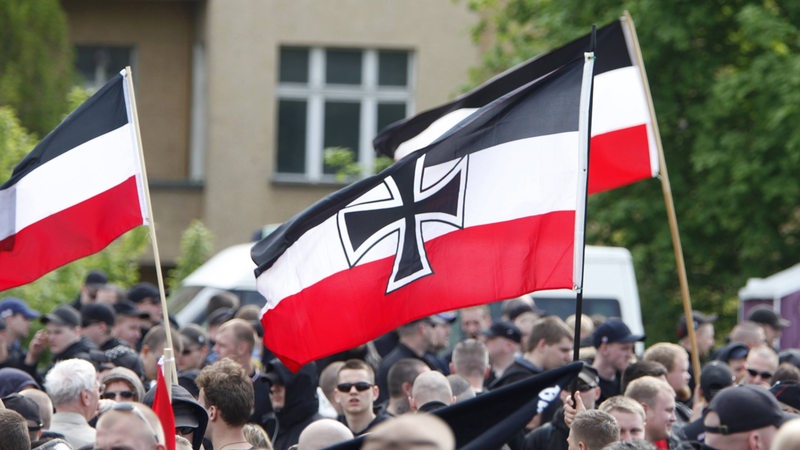 Bei einer Demonstration in Berlin haben Teilnehmer auch eine Reichskriegsflagge in der Hand.