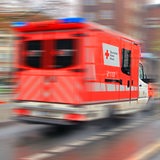 Ein Rettungswagen fährt eine verschwommene Straße entlang.