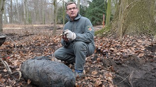 Der Sprengmeister der Bremer Polizei, Andreas Rippert, zeigt sich am 20.02.2013 nach der Entschärfung mit Zünder und Sprengsatz einer Fliegerbombe aus dem 2. Weltkrieg im Bremer Bürgerpark.