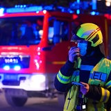 Feuerwehrfahrzeug und Mann bei Nacht (Symbolbild)