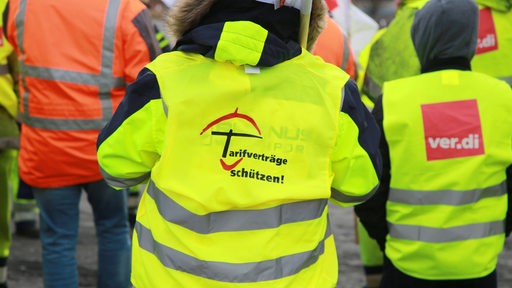 Hafenarbeiter mit Warnwesten protestieren in Bremen (Archivbild)