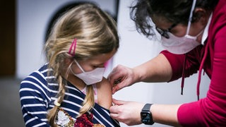 Ein junges Mädchen wird von einer Ärztin geimpft.