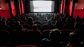 Zuschauer sitzen mit Abstand in einem Kinosaal (Archivbild)