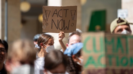 Klimademo-Teilnehmende halten Plakate hoch (Archivbild)