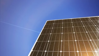 Nahaufnahme einer Solarzelle mit schönem Himmel im Hintergrund (Symbolbild)